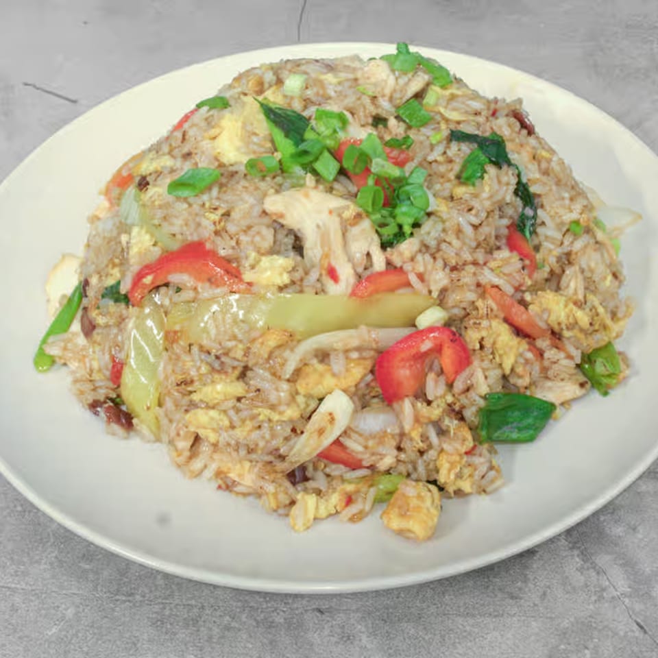 Thai Bliss fried rice with chicken, egg, red bell peppers, and green onions on a white plate.